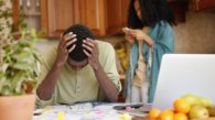 Desperate dark-skinned male touching head with both hands, feeling absolutely devastated, can't stand financial pressure, not able to pay gas and electricity bills anymore because of many debts