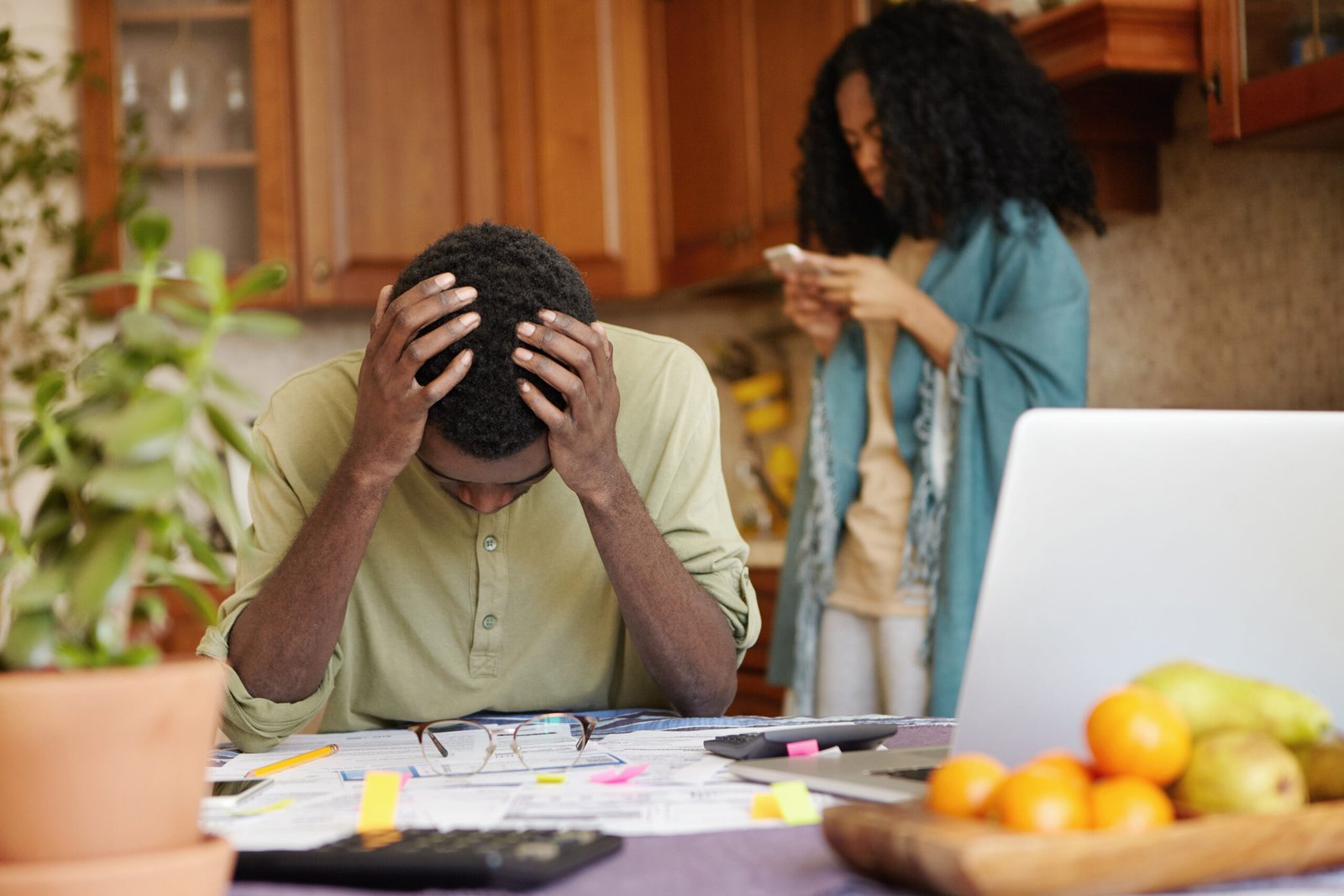 Desperate dark-skinned male touching head with both hands, feeling absolutely devastated, can't stand financial pressure, not able to pay gas and electricity bills anymore because of many debts